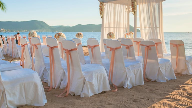 Boda destino romántica en la playa con sillas adornadas